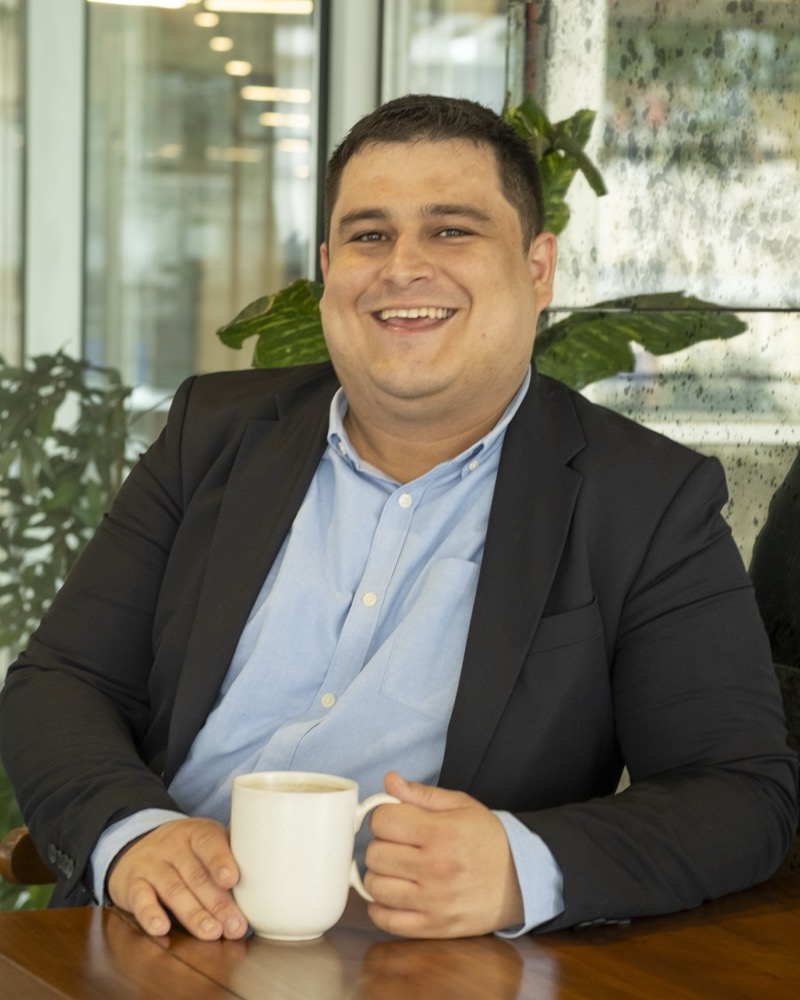 Levent Asanoski, fundador de VIRA, sentado a una mesa con una taza de café